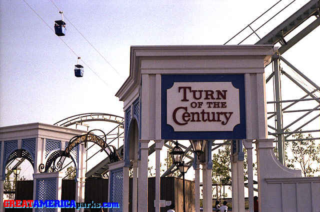 [i]Turn of the Century[/i] sign
Gurnee, IL -- 1977
This sign marked the entrance to the [i]Turn of the Century[/i] roller coaster. The name, [i]Turn of the Century[/i] also appeared in gold letters on the black arch over the entrance, visible here to the left of the larger sign. Also visible are two cabins of the Southern Cross skyride as they pass over [i]Turn of the Century[/i].
Keywords: Gurnee