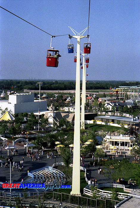 County Fair
Gurnee, IL -- 1977
This Southern Cross tower was located in County Fair, near the entrance of the [i]Turn of the Century[/i] roller coaster. To the left of the tower is a portion of the queue structure for the [i]Turn of the Century[/i]. In the foreground is the coaster's run from the station to the lift hill. 
