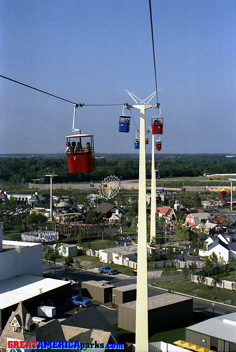 Hometown Square
Gurnee, IL -- 1977
This tower was located in Hometown Square. In this photo, to the left of and below the red cabin number seven, the Spinnaker ride is visible on the site where the Tidal Wave roller coaster would be built the following year.
